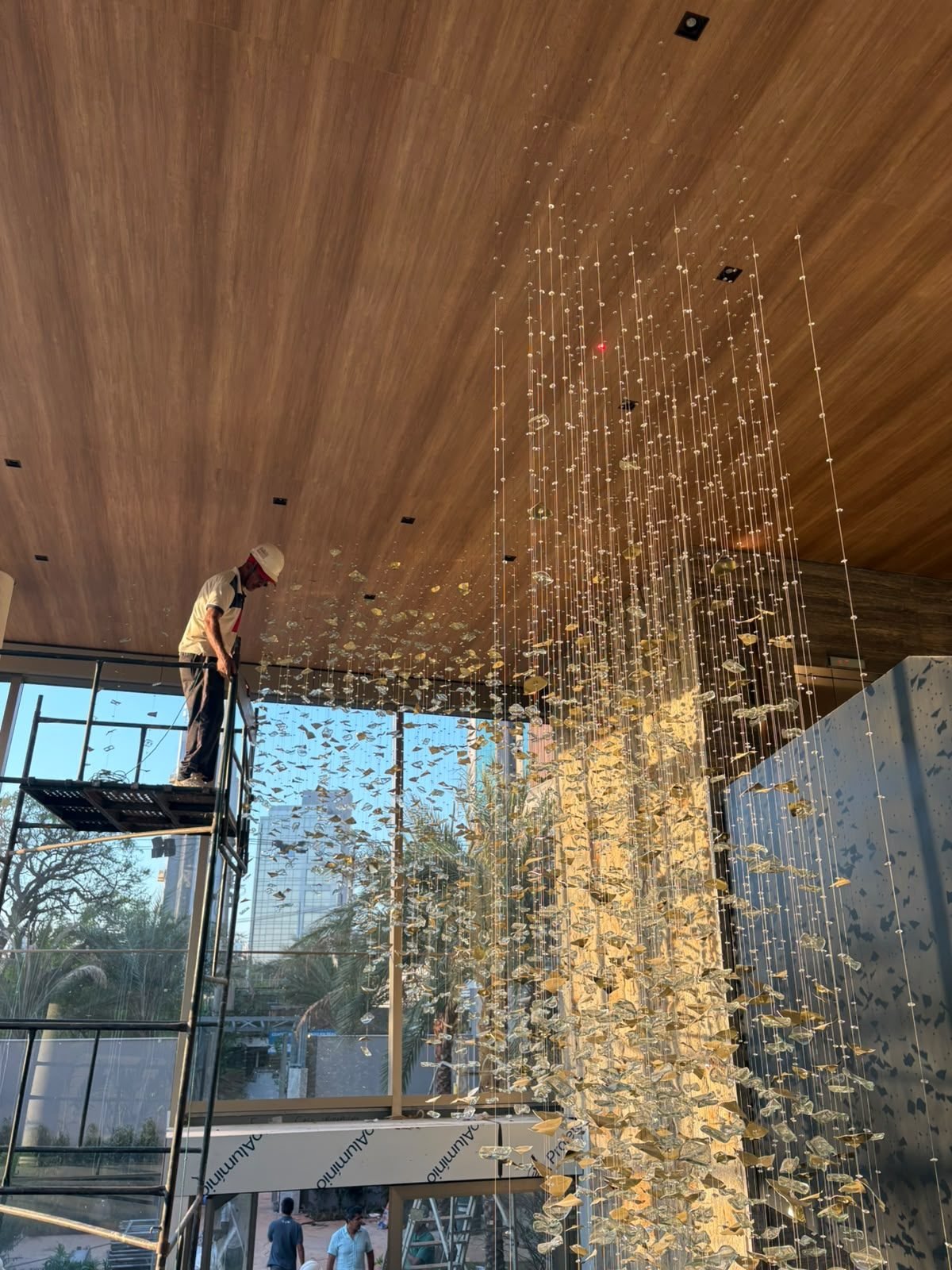 Casa Ibirapuera — Cascata sobre a Escada em Espiral — Cascata iluminada ao entardecer, vista da fachada de vidro