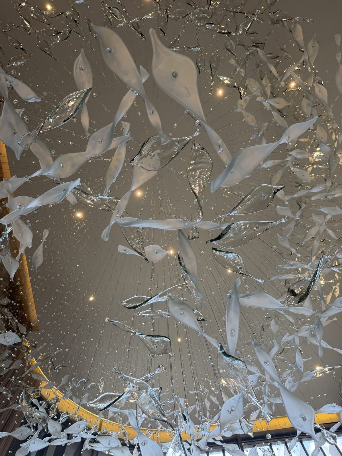 Casa Ibirapuera Torre 3 — Espiral de Folhas e Cristal no Lobby — Detalhe das folhas suspensas e fios de cristal, vista de baixo