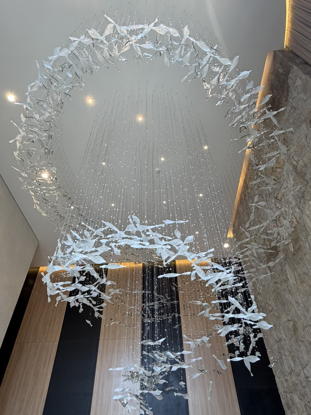 Casa Ibirapuera Torre 3 — Espiral de Folhas e Cristal no Lobby — Espiral finalizada, com a parede em pedra natural ao fundo