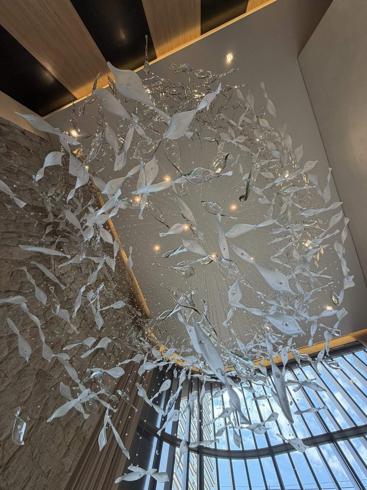 Casa Ibirapuera Torre 3 — Espiral de Folhas e Cristal no Lobby — Espiral vista de baixo contra os caixilhos da fachada