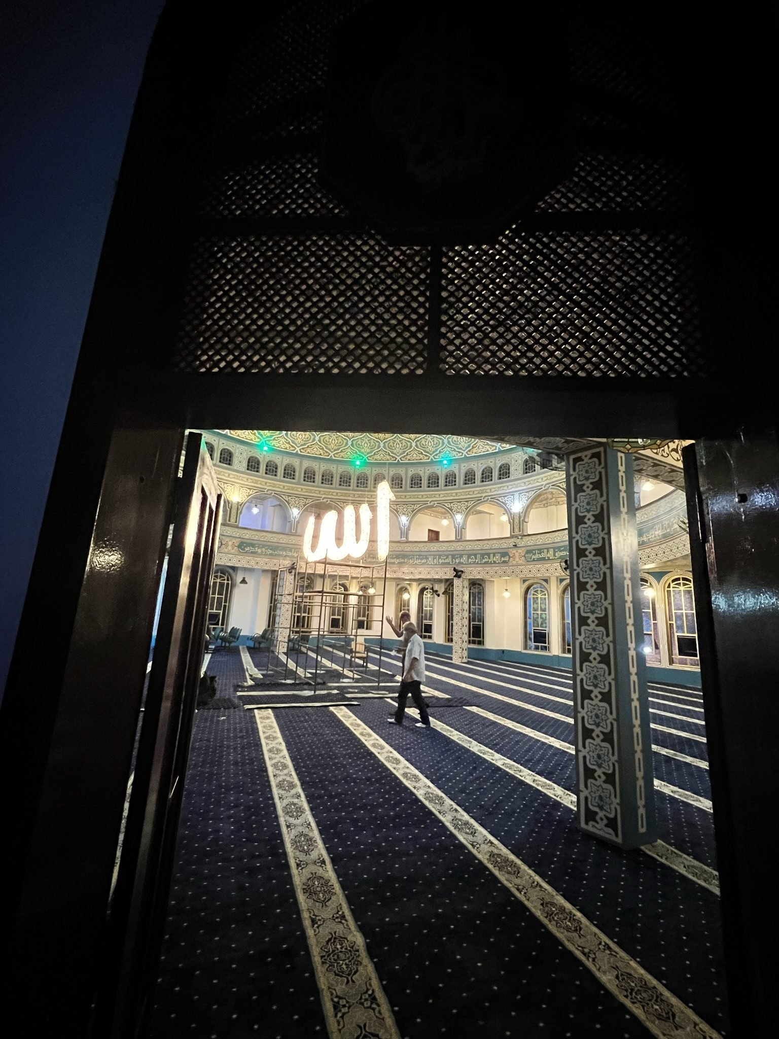 Mesquita Santo Amaro — Caligrafia luminosa vista pela porta do salão, ainda em obra