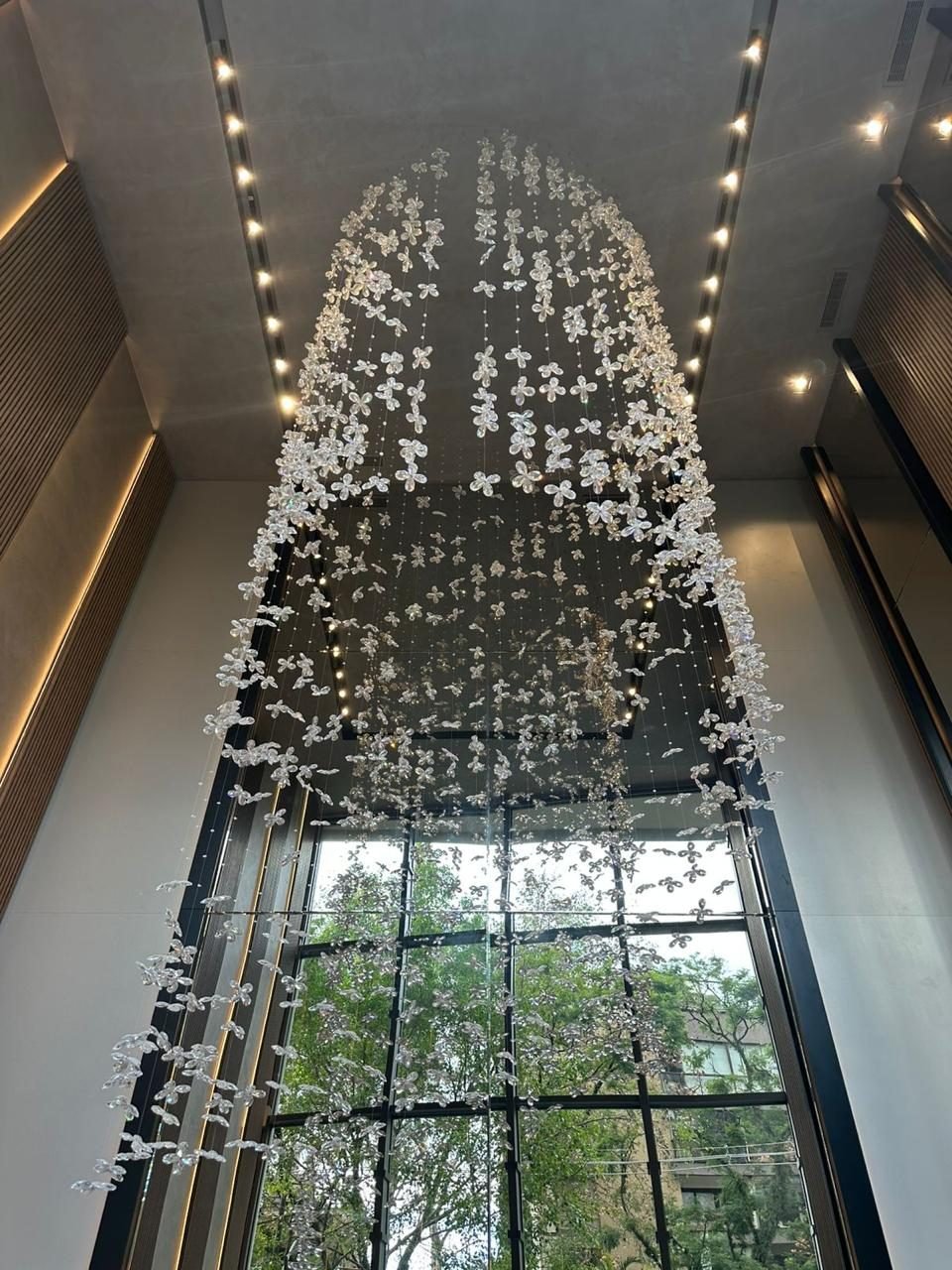 Legacy Powered by Porsche Consulting - Porto Alegre — Arco de cristal em flores suspensas, vista pela janela