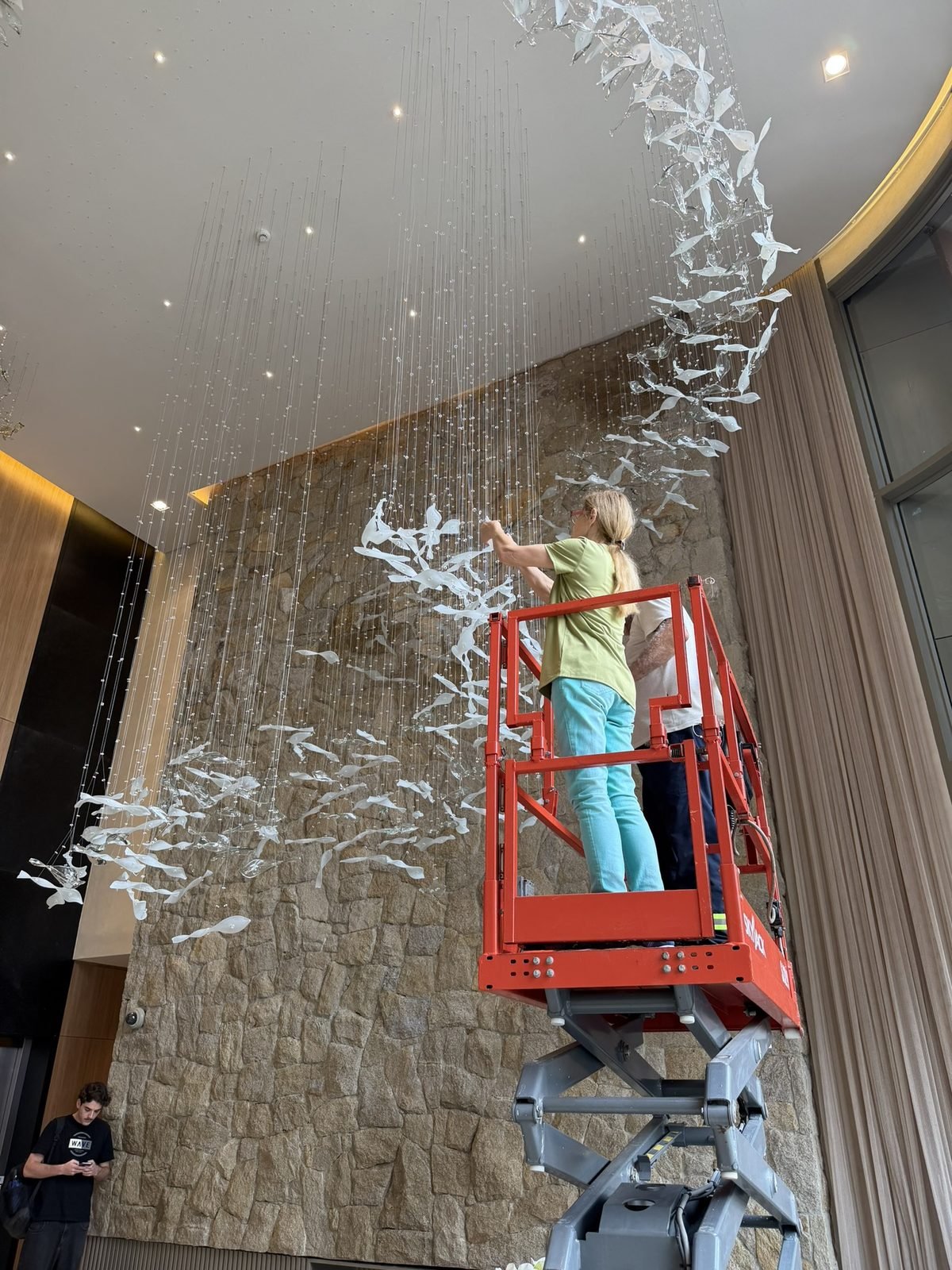 Casa Ibirapuera Torre 3 — Espiral de Folhas e Cristal no Lobby — Instalação em andamento sobre a plataforma elevatória