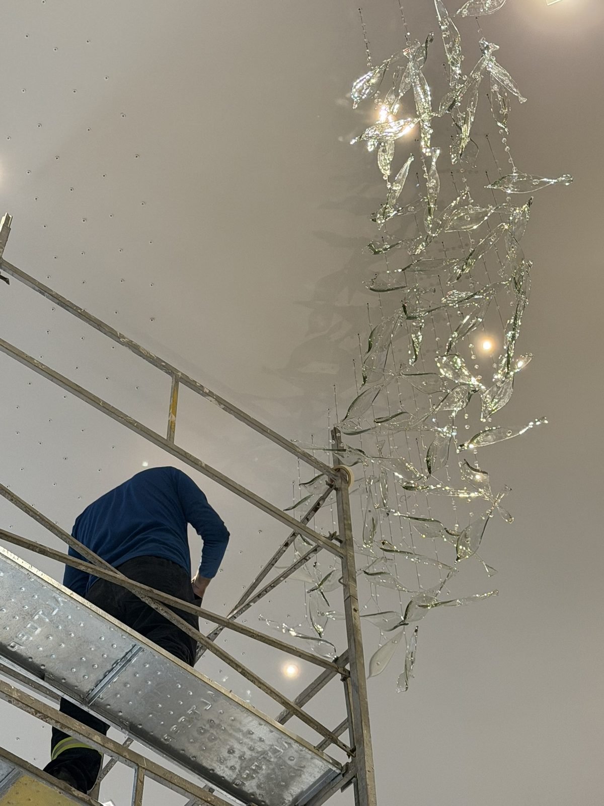 Casa Ibirapuera Torre 3 — Espiral de Folhas e Cristal no Lobby — Montador fixando os fios da espiral