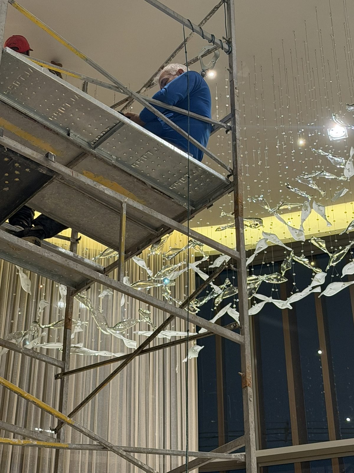 Casa Ibirapuera Torre 3 — Espiral de Folhas e Cristal no Lobby — Equipe no andaime ajustando as folhas da espiral