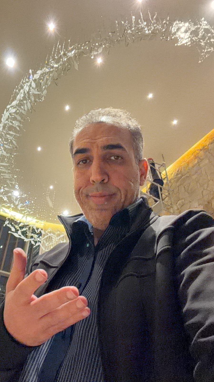 Casa Ibirapuera Torre 3 — Espiral de Folhas e Cristal no Lobby — Mohammed Darwich no lobby, com a espiral instalada ao fundo