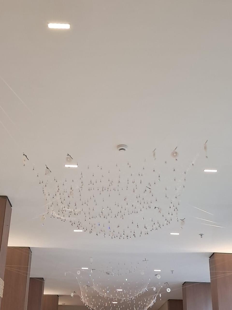 Cyrela N.A.U. Klabin — Rede de Cristal — Vista geral do corredor do lobby com a rede de cristal, entre as colunas em madeira e corda
