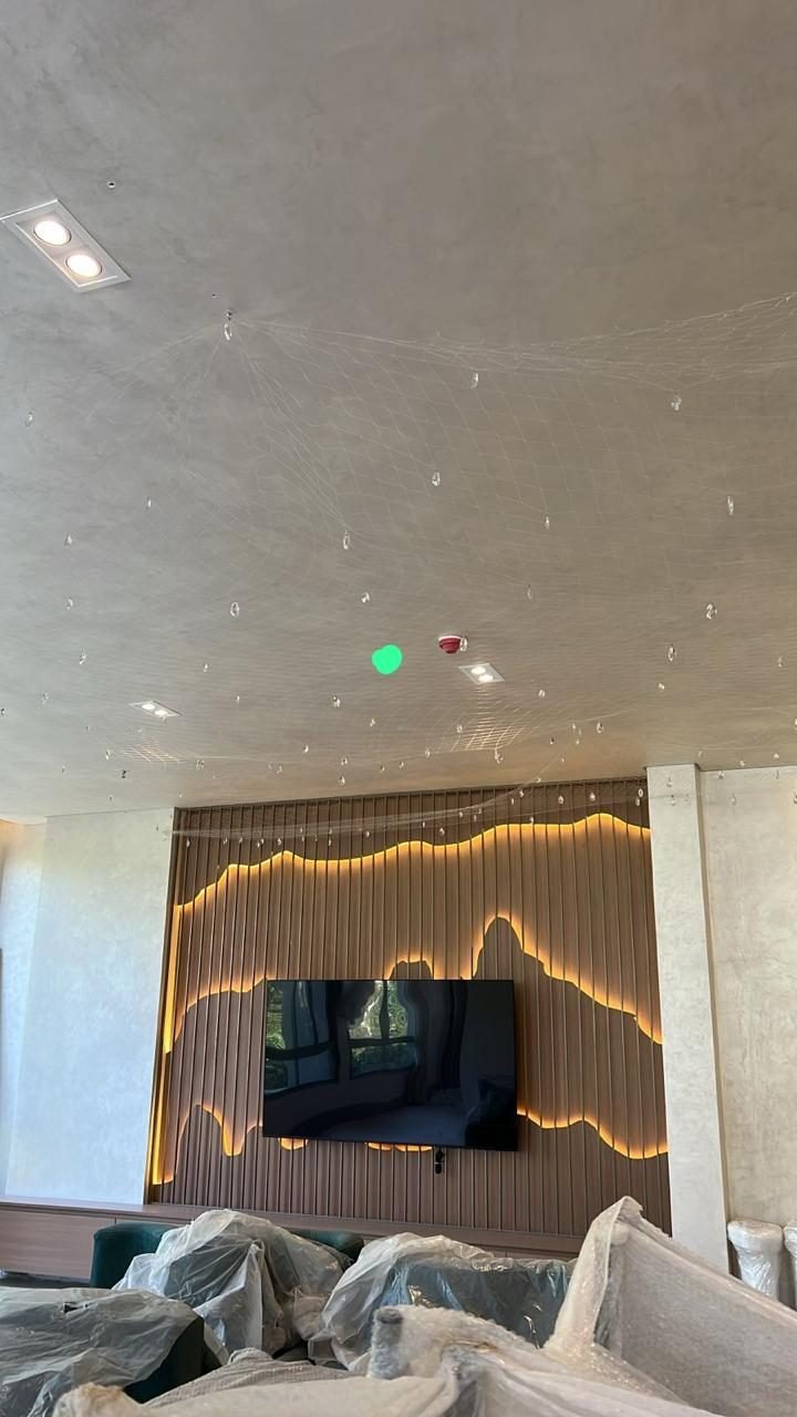 Cyrela N.A.U. Klabin — Rede de Cristal — Rede de cristal instalada no salão de festas, junto ao painel de madeira ondulado