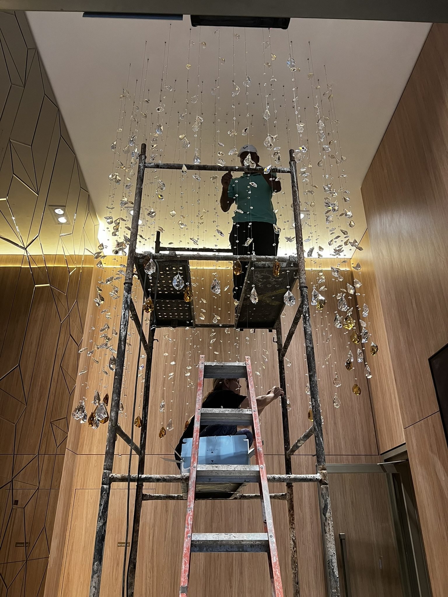 Cyrela Oscar Freire 1560 — Chuva de Cristal Âmbar — Equipe em andaime durante instalação da chuva de cristal