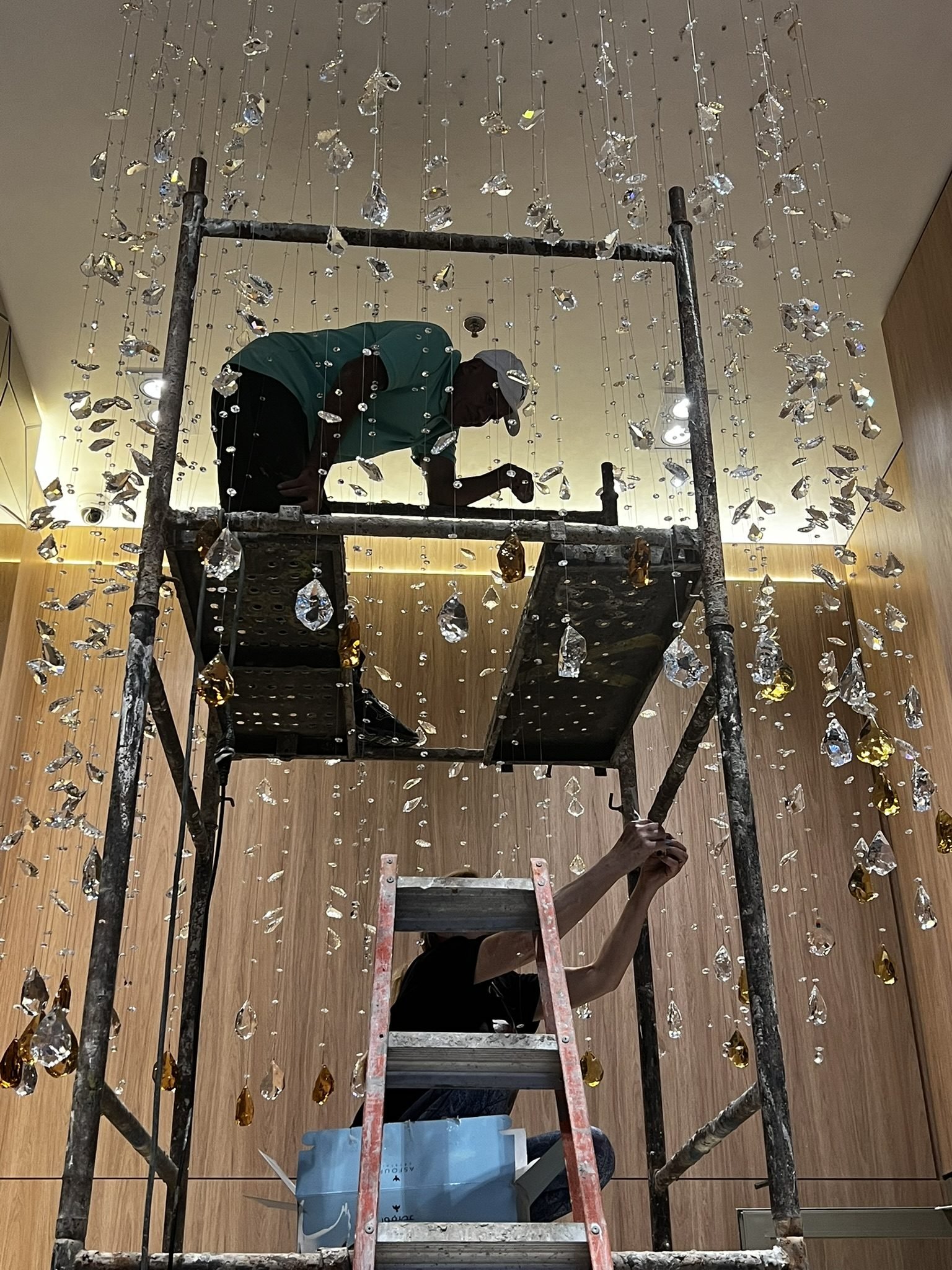 Cyrela Oscar Freire 1560 — Chuva de Cristal Âmbar — Equipe em andaime durante instalação da chuva de cristal